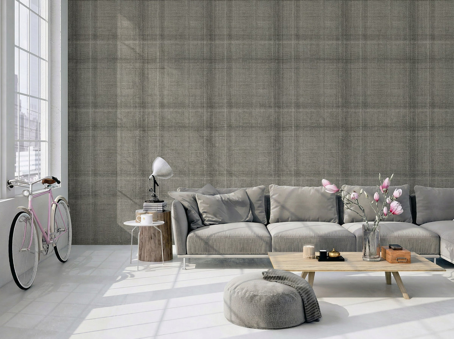 Modern living room with Textured Plaid Commercial Vinyl, gray sofa, pouf, coffee table, flowers, lamp, and bike by windows.
