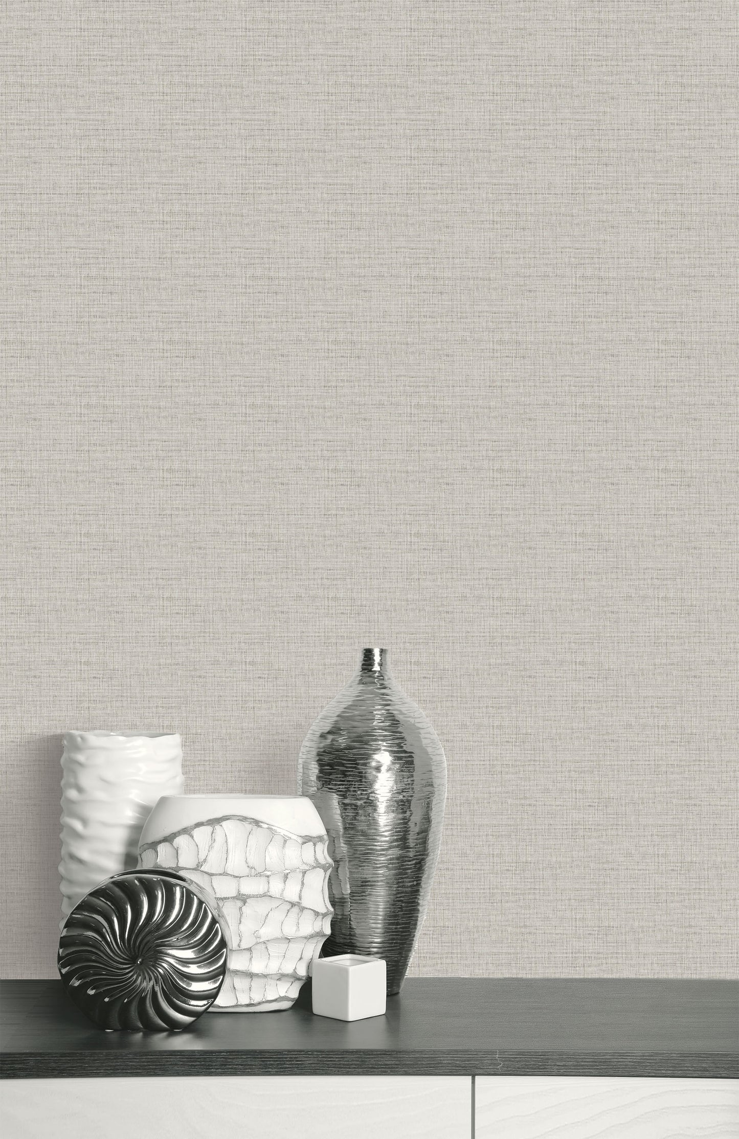 Silver and white vases on a dark table complement the Faux Weave Commercial Vinyl wallpaper on the textured wall.