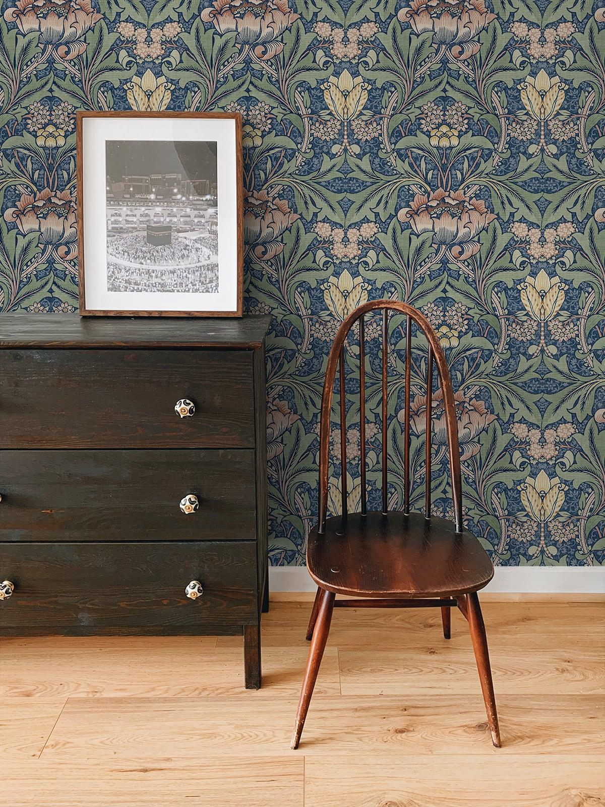 A dark wood dresser and wooden chair sit against a wall covered in Bear's Breeches Peel Stick wallpaper.