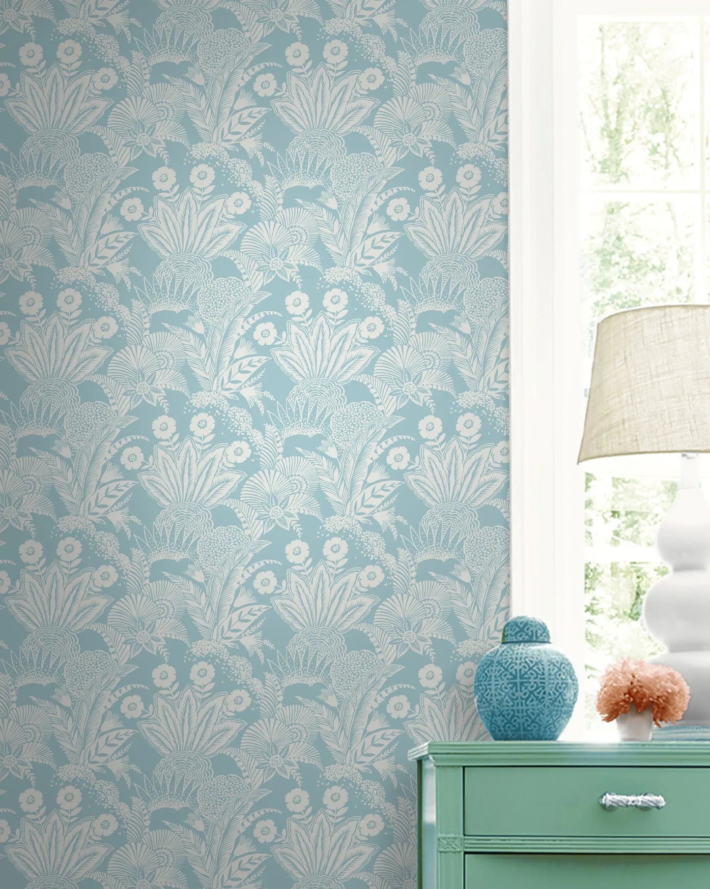 Palm Garden Wallpaper sets a tropical tone, with a green chest, vases, and sunlight streaming in by the window.