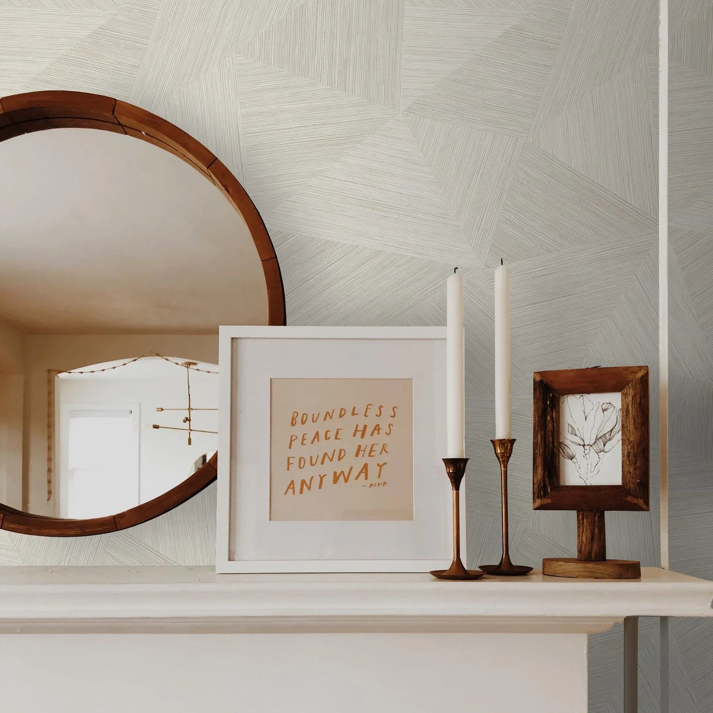Round mirror, framed quote, and art on a white mantel against Geometric Fibers Triangles Commercial Vinyl wallpaper.