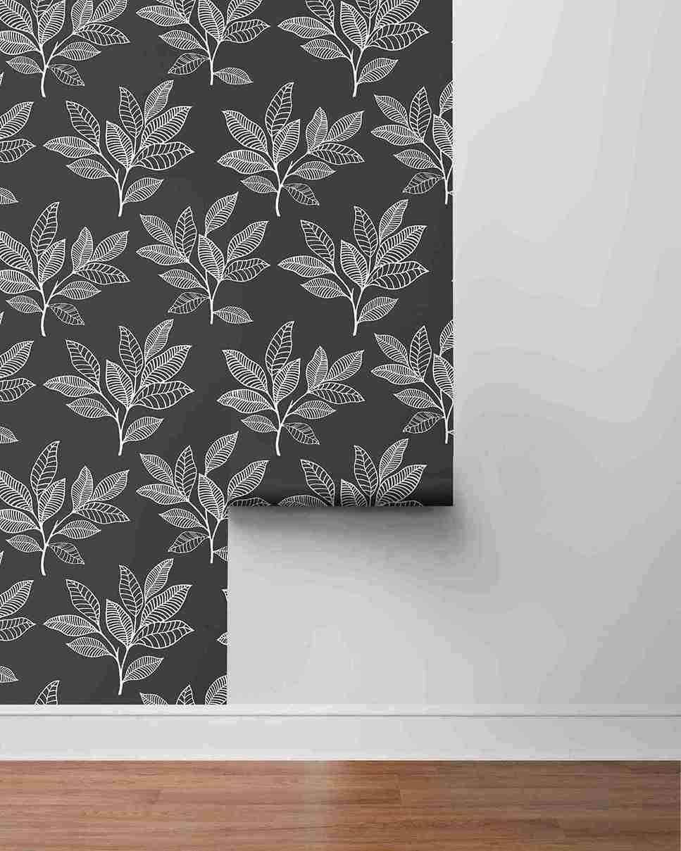 Stylized Leaves Peel Stick wallpaper: black with white leafy branches, shown above a gray wall and white baseboard.