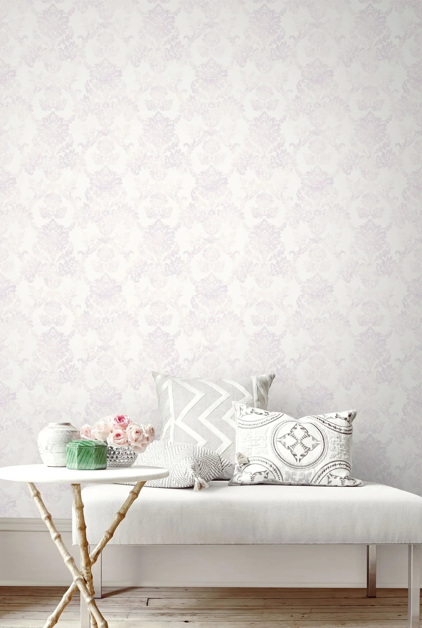 White bench with patterned cushions and flowers, set against a wall featuring French Damask Wallpaper.