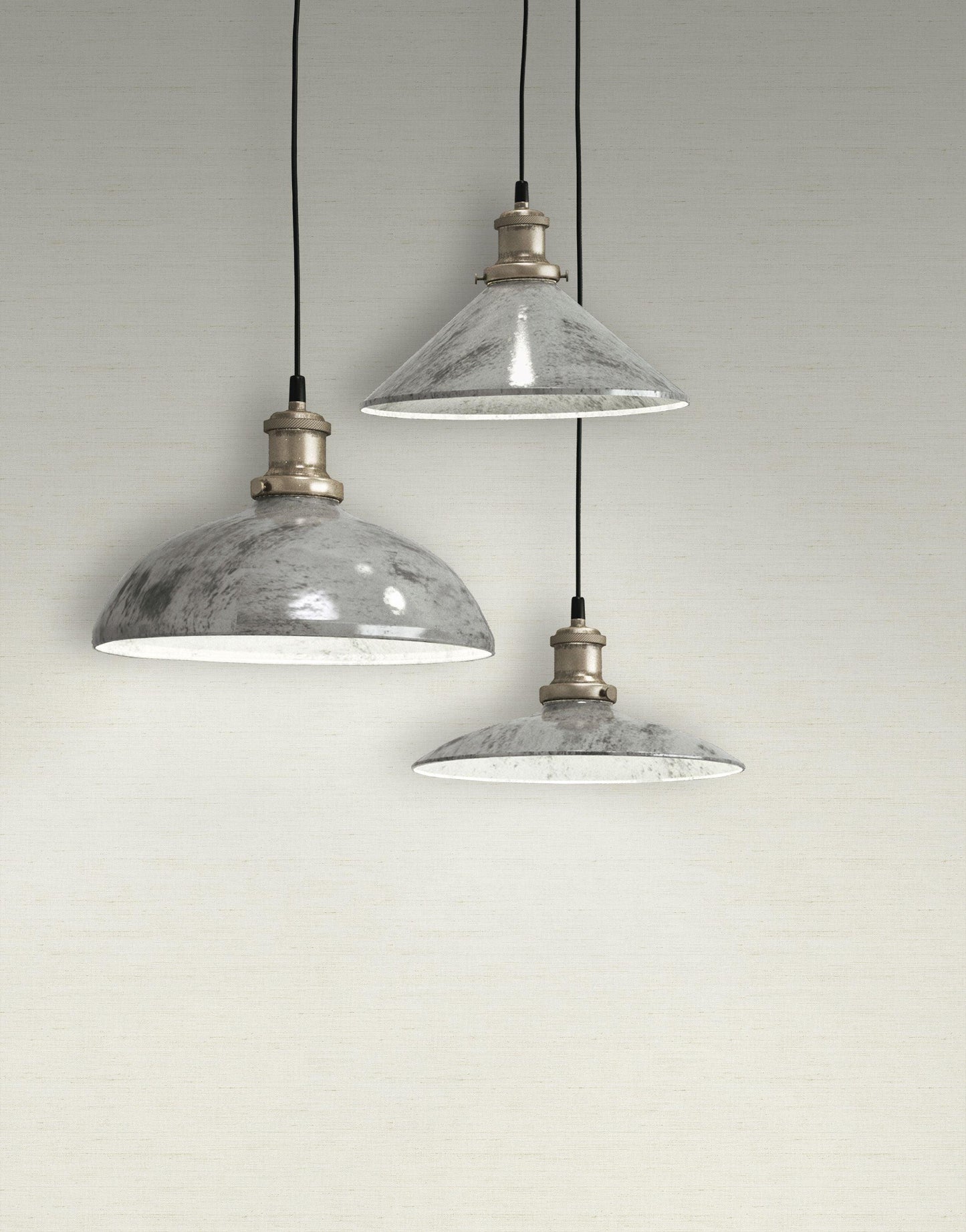 Three industrial pendant lights with black cords hang against a wall covered in Plain Tapestry Wallpaper.
