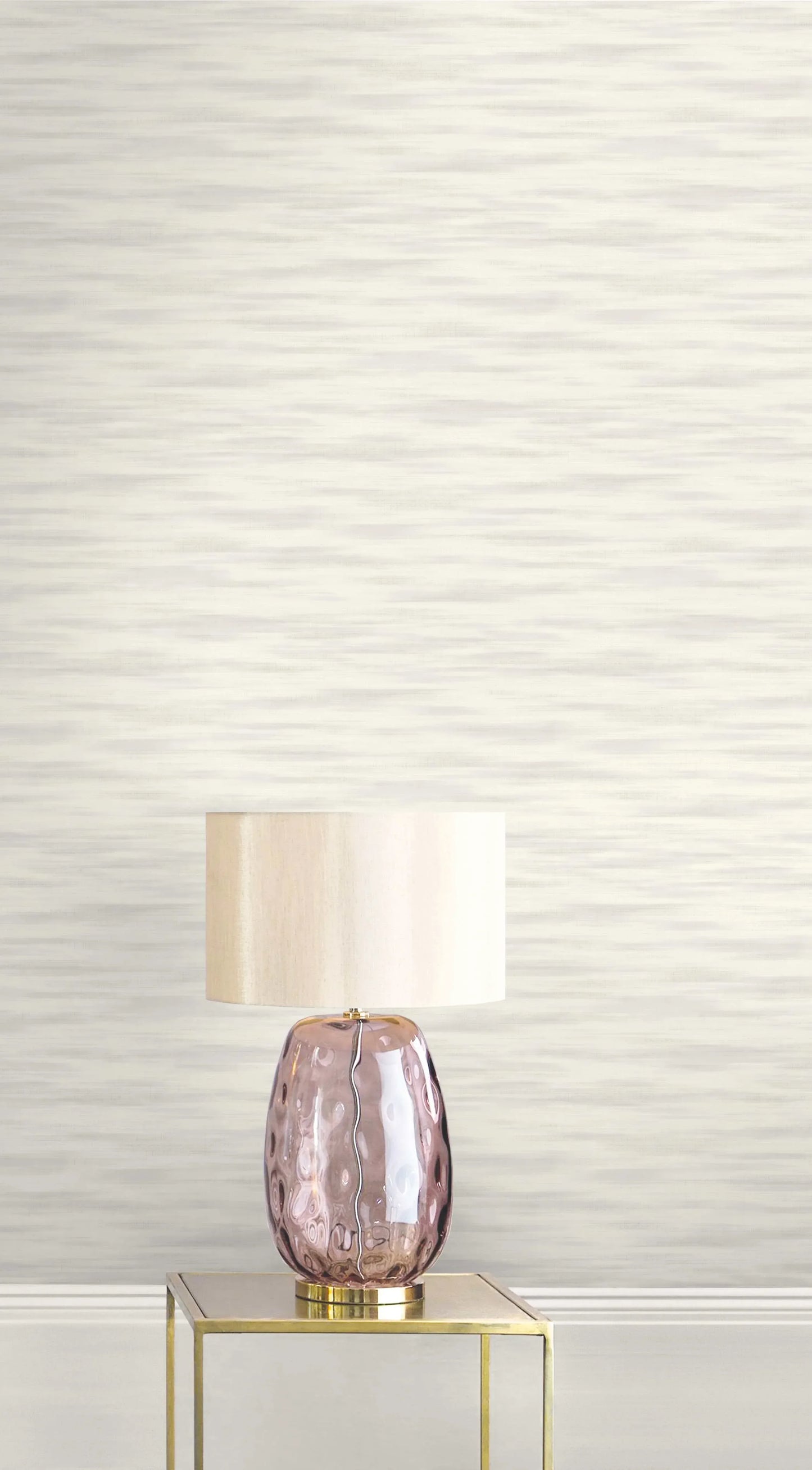 Purple glass table lamp with cream shade on gold table, set against Metallic Plain Wallpaper and a light textured wall.