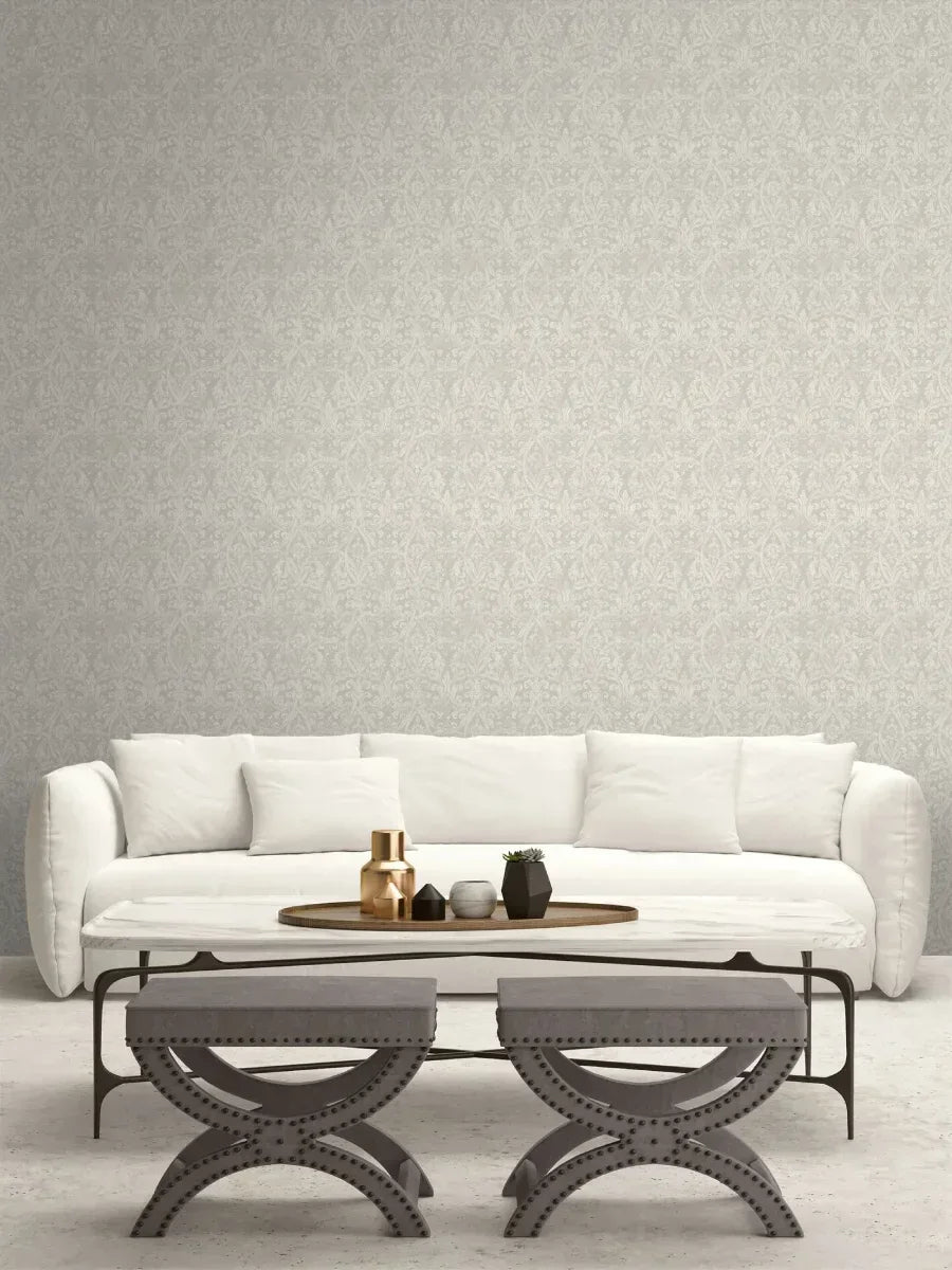 A modern living room with a white sofa, round coffee table, and gray ottomans against Gothic Wallpaper.
