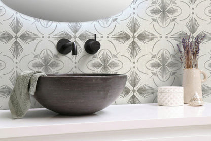 Modern bathroom with a stone sink, gray Tropical Bali Essence Grasscloth wallpaper, towel, and decor on a white countertop.
