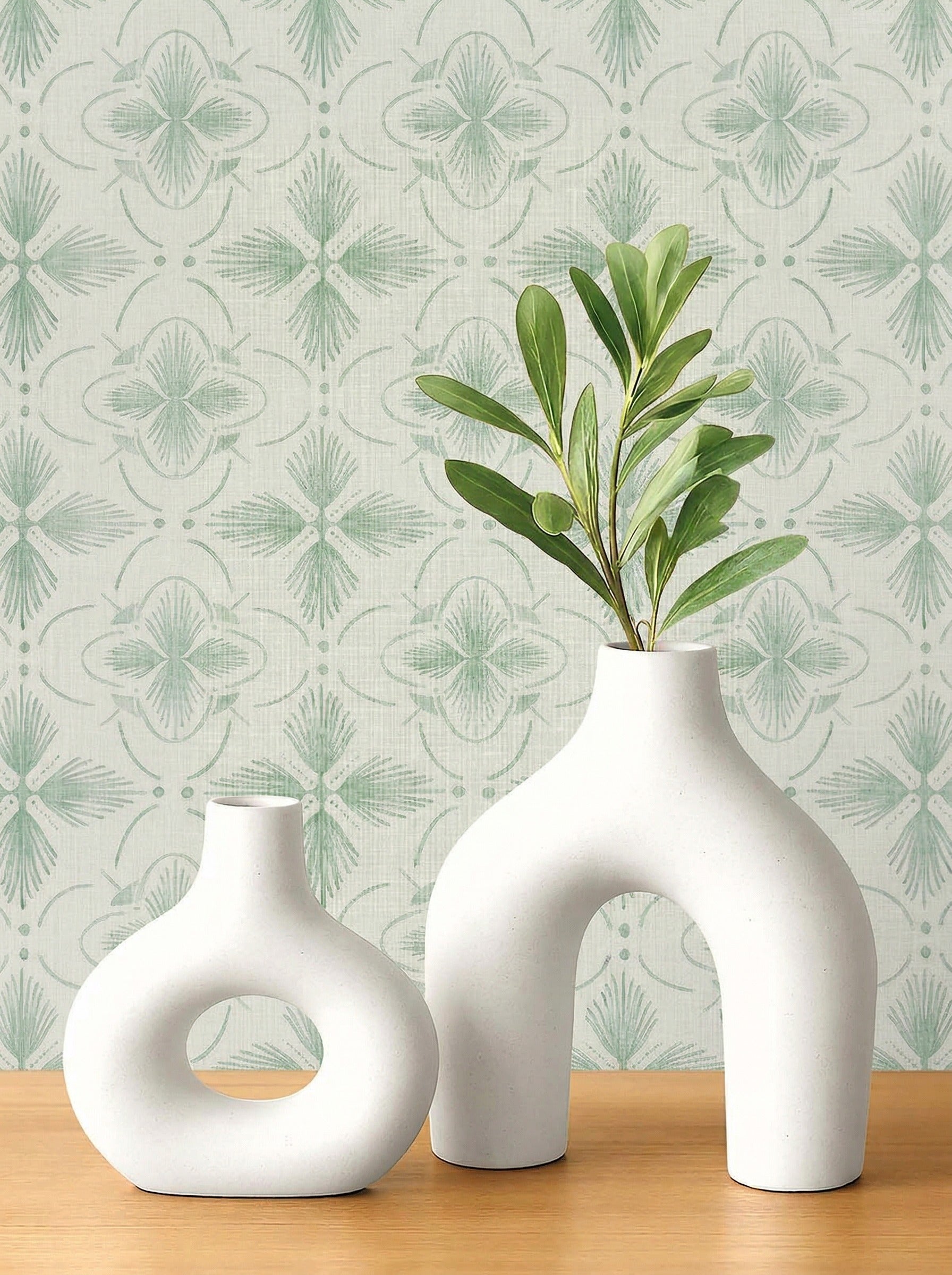 Two modern white vases with green leaves on wood; background: Tropical Bali Essence Grasscloth Naturals in green.