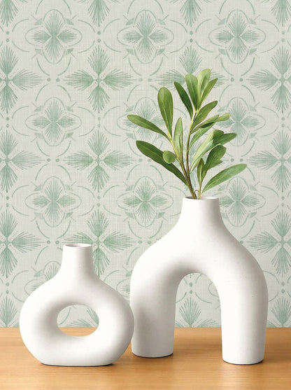 Two modern white vases with green leaves on wood; background: Tropical Bali Essence Grasscloth Naturals in green.