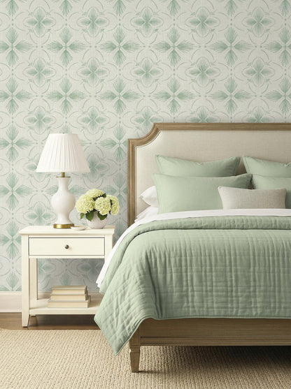 A neatly made bed with green bedding, a nightstand, and Tropical Bali Essence Grasscloth Naturals wallpaper behind.