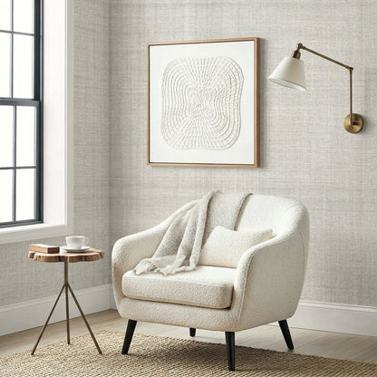 A Textured Plaid Commercial Vinyl armchair with pillow and blanket sits by a small table and wall art in a bright room.