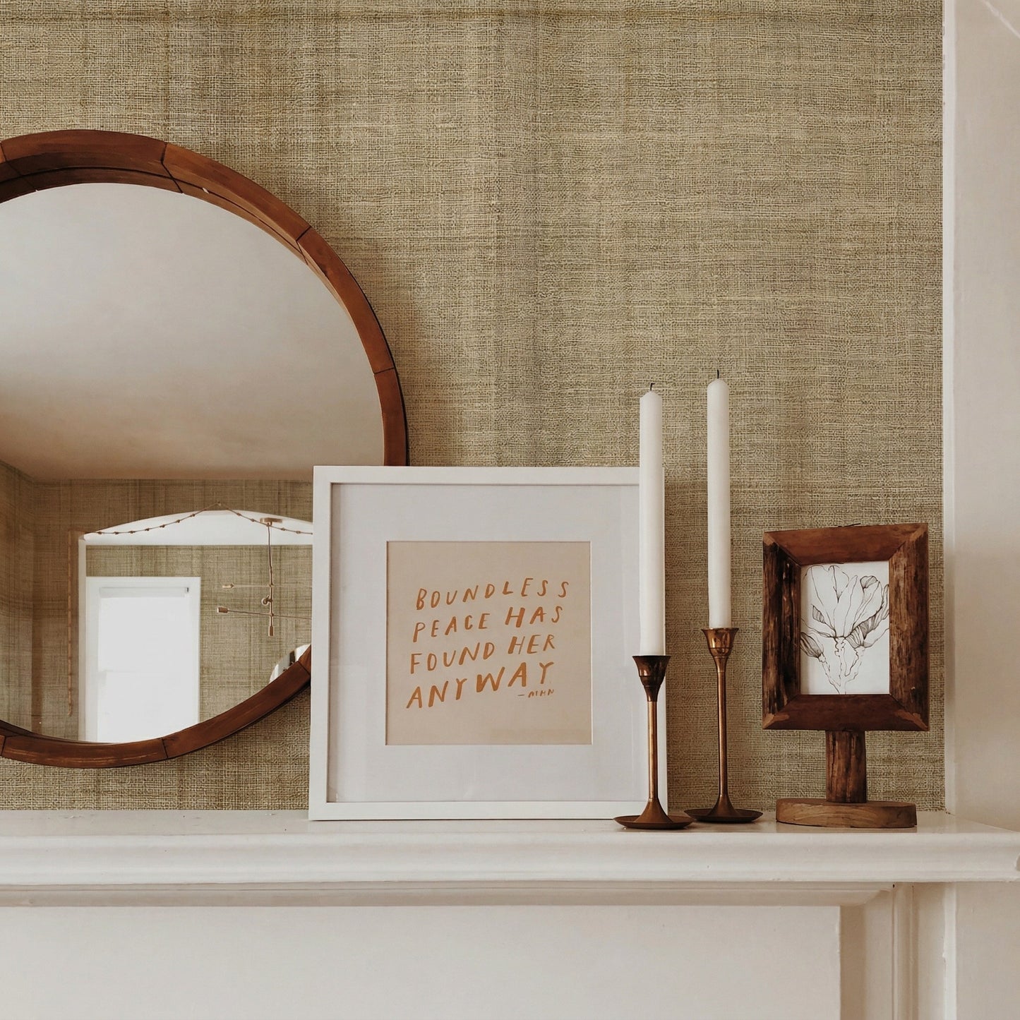 Round mirror, framed quote, candlesticks, and art on a white mantel against Textured Plaid Commercial Vinyl in Beige.
