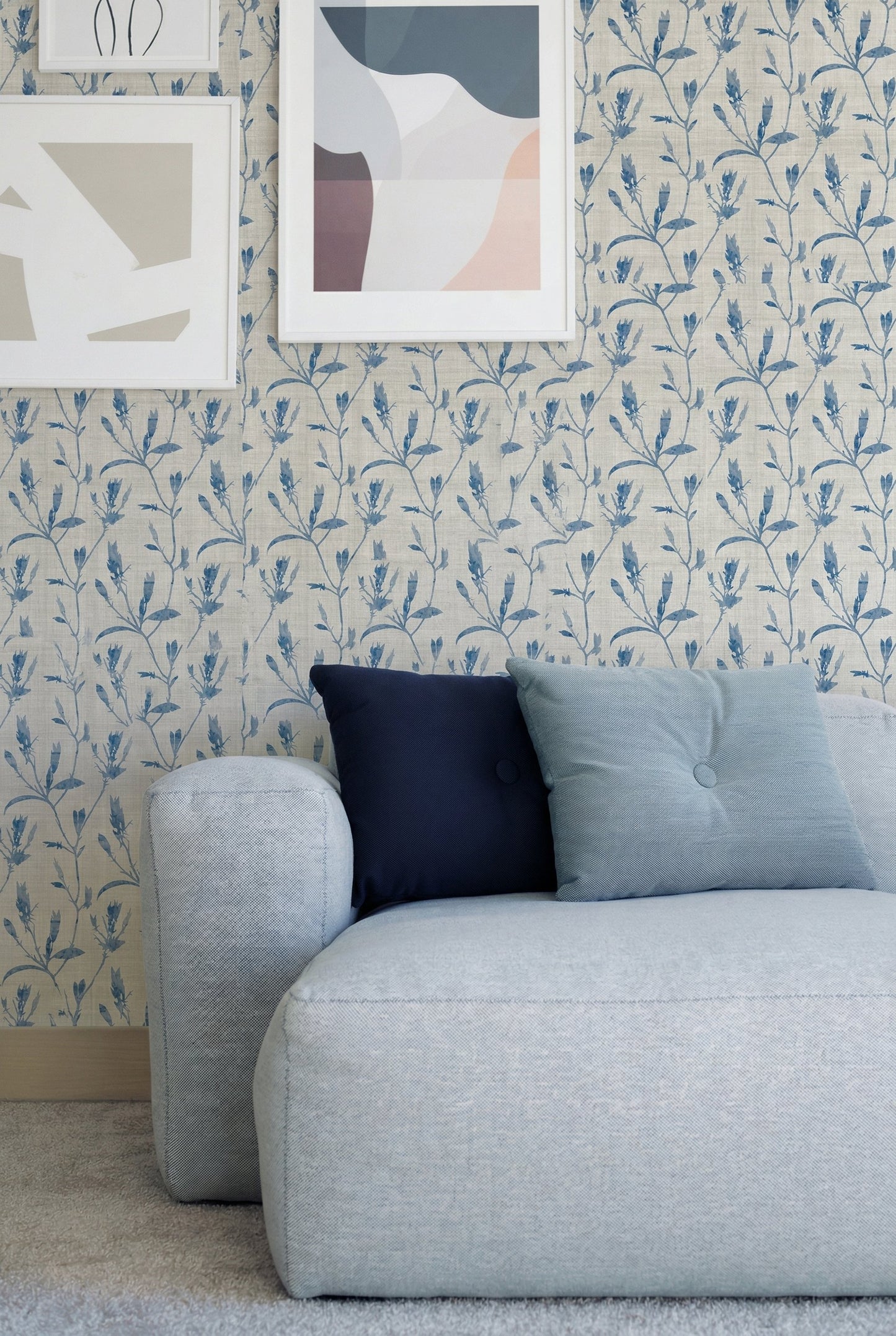 Light blue sofa with navy and pale blue pillows against Botanical Bali Leaf Commercial Vinyl, abstract art above.