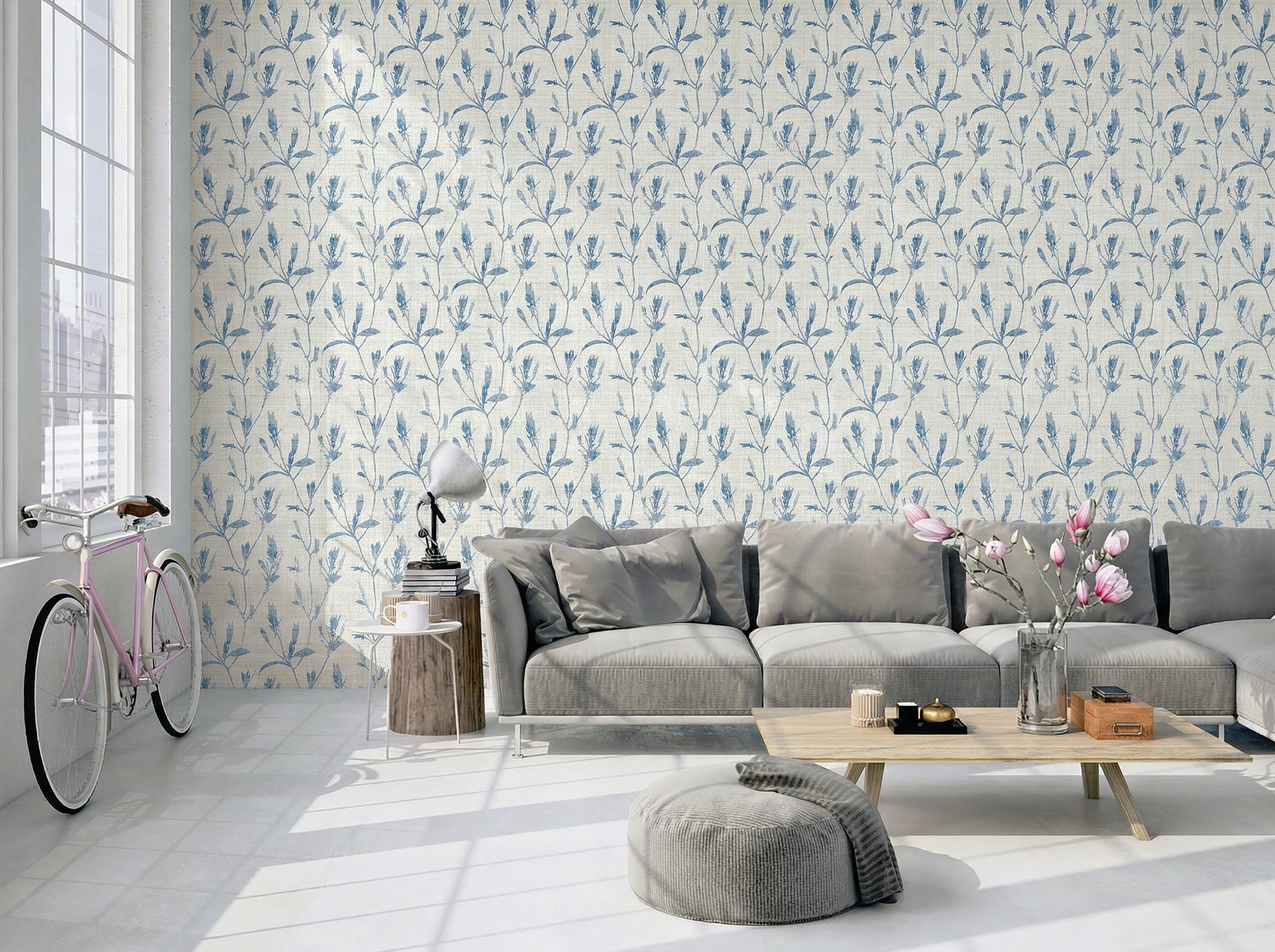 Modern living room with gray sofa, wood table, pink bike Botanical Bali Leaf Commercial Vinyl wallpaper. Sunlit windows.