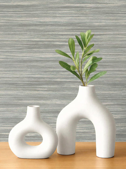 Two modern white ceramic vases on wood with Faux Grasscloth Commercial Vinyl wallpaper in a stylish living area.