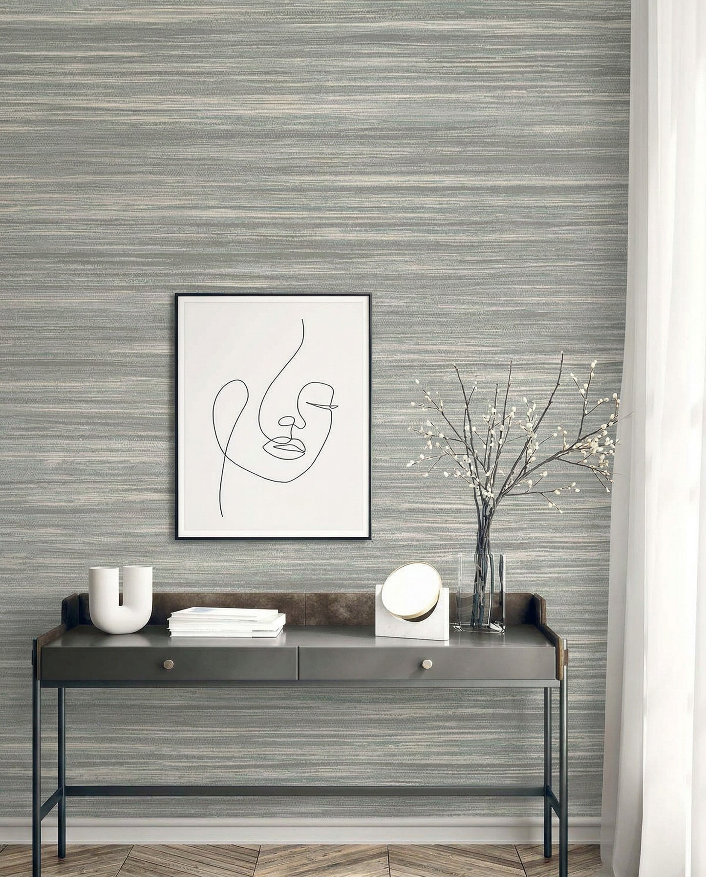 Minimalist console table with decor and abstract face art set against Faux Grasscloth Commercial Vinyl wallpaper.