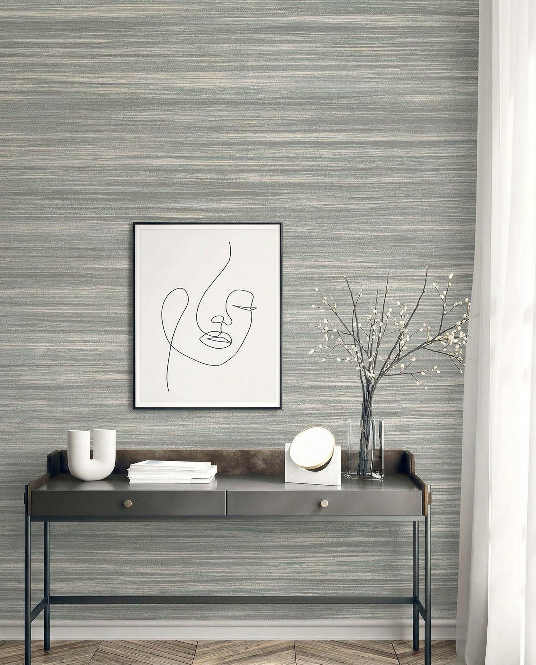 Minimalist console table with decor and abstract face art set against Faux Grasscloth Commercial Vinyl wallpaper.