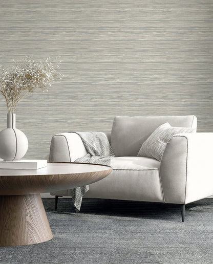 Modern living room with Faux Grasscloth Commercial Vinyl wallpaper, white armchair, gray throw, and round wooden table.