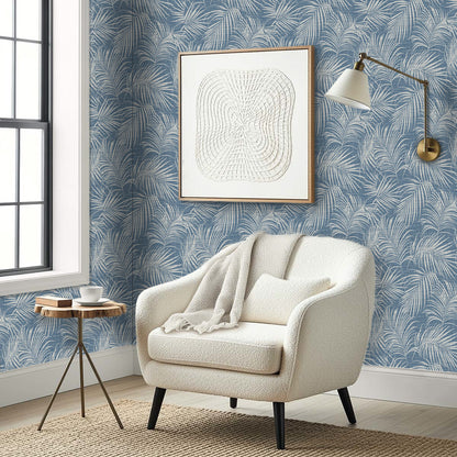 Cozy armchair, blanket, side table, and wall art set against Palm Grassland Commercial Vinyl blue wallpaper.