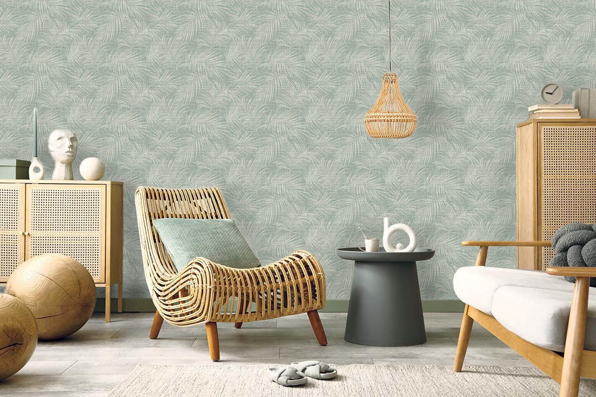 Cozy living room with Palm Grassland Commercial Vinyl, rattan furniture, botanical prints, and light green walls.
