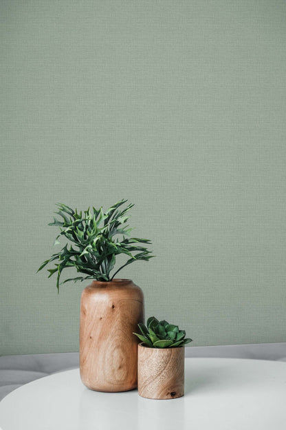Faux Weave Commercial Vinyl wallpaper pairs with potted plants on a white table for a modern living space.