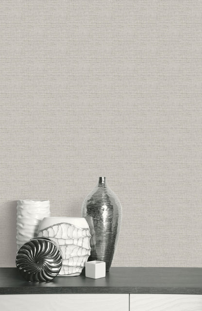Silver and white vases on a dark table complement the Faux Weave Commercial Vinyl wallpaper on the textured wall.