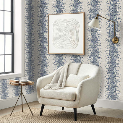A cozy white armchair with a blanket sits by a table in a modern room with Tropical Bali Leaf Stripe Vinyl wallpaper.