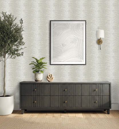 A modern console table with plants, decor, wall art, and a sleek sconce set against Tropical Bali Leaf Stripe Vinyl.