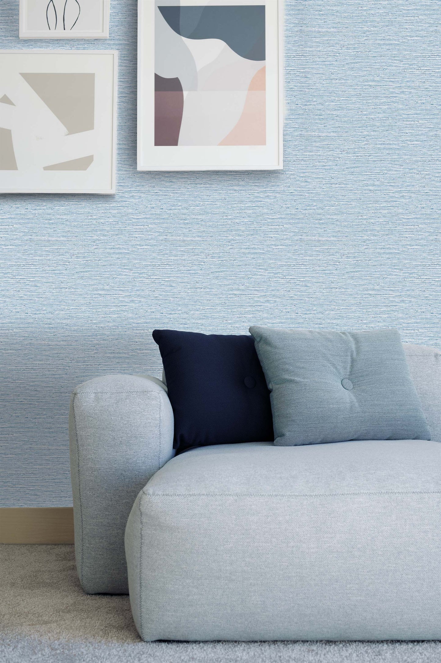 Modern light blue sofa with two pillows, set against Texture Grasscloth Effect Commercial Vinyl wallpaper and abstract art.