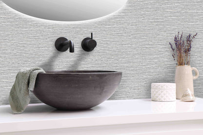 Modern bathroom sink with a towel, lavender vase, and containers beside Texture Grasscloth Effect Commercial Vinyl.