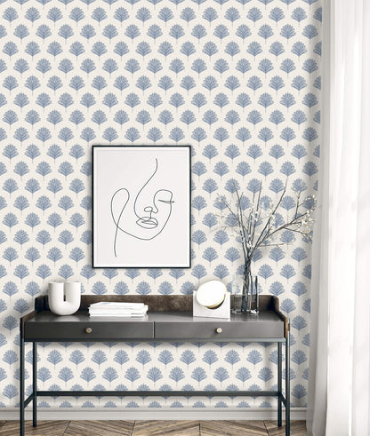 A console table with decor sits against Indian Botanical Commercial Vinyl wallpaper and a minimalist face art print.