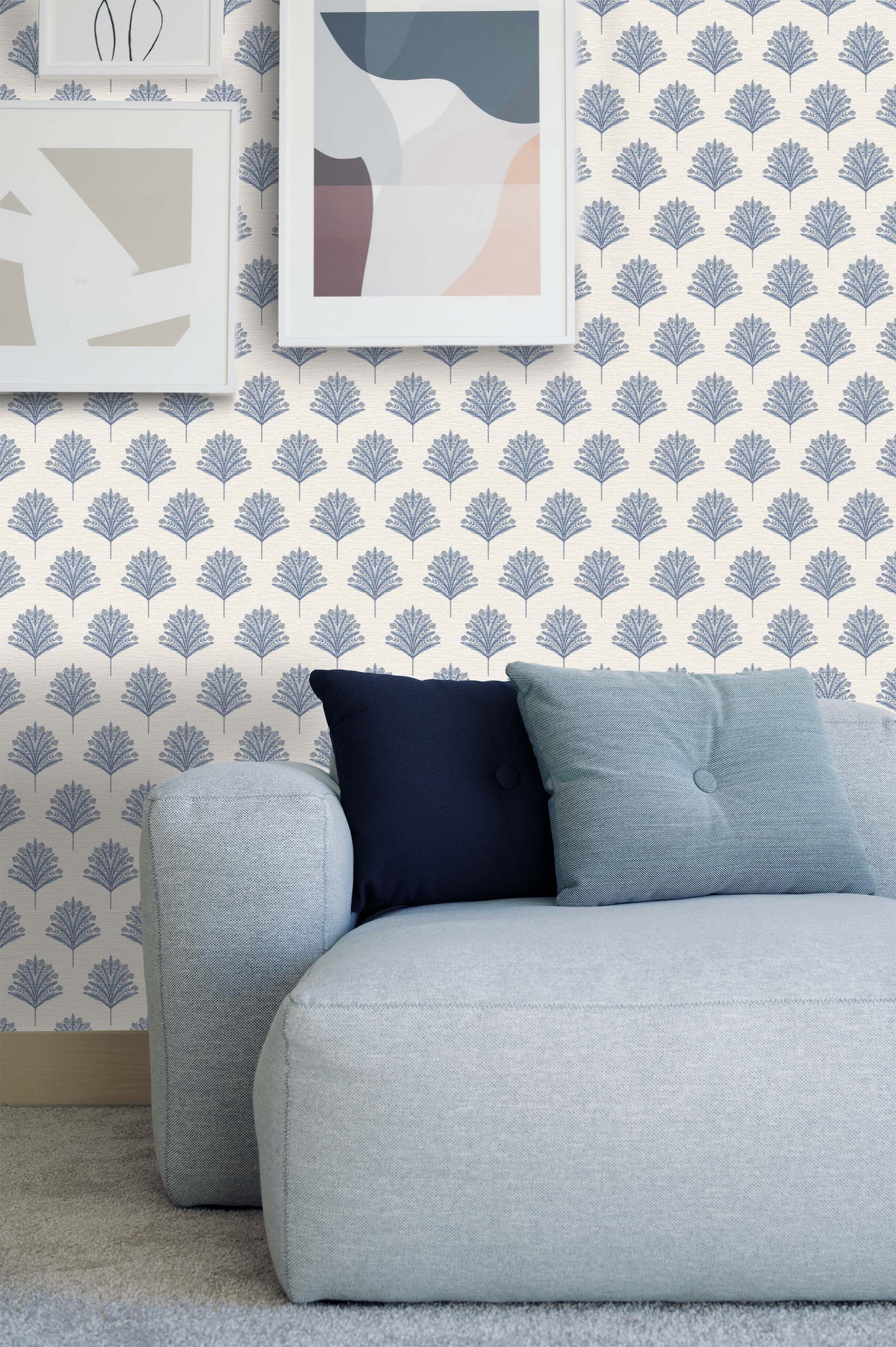 Light blue couch with two pillows against a wall with Indian Botanical Commercial Vinyl wallpaper and abstract art.