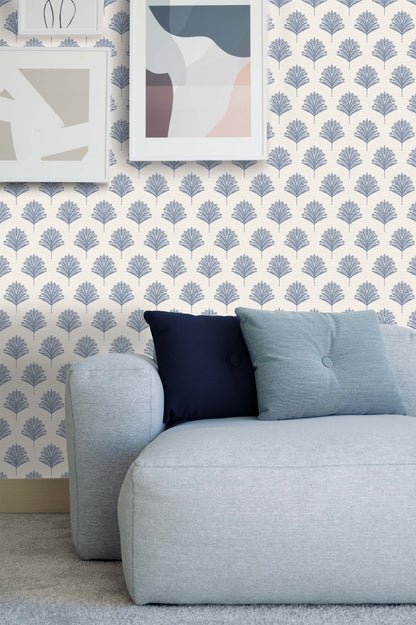 Light blue couch with two pillows against a wall with Indian Botanical Commercial Vinyl wallpaper and abstract art.
