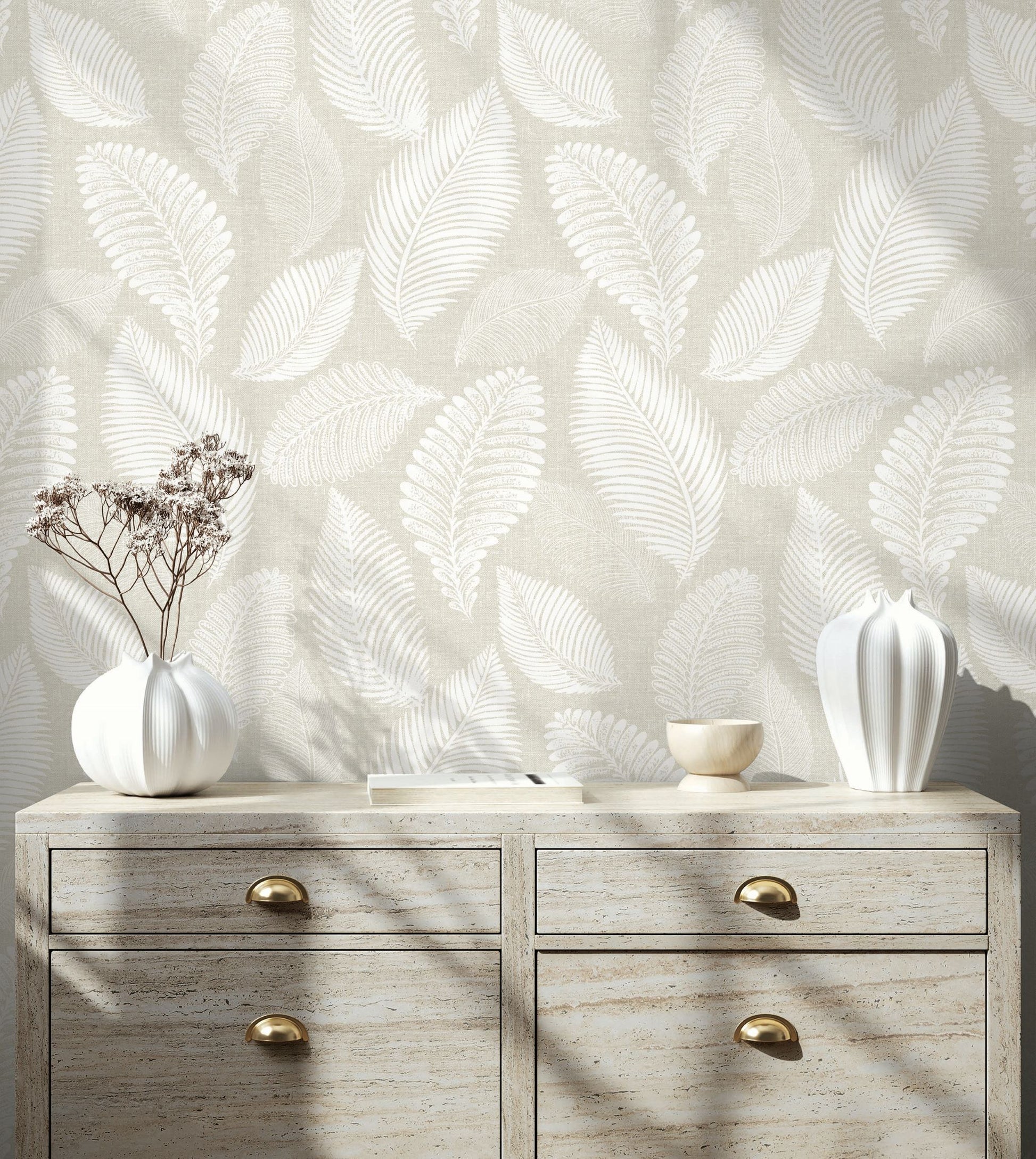 Wooden dresser with decorative vases against a wall decorated with White/Off White Scattered Leaves Wallpaper.
