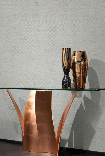 Glass table with copper base, vases, and Raffia Texture Grasscloth Naturals wallpaper in the background.