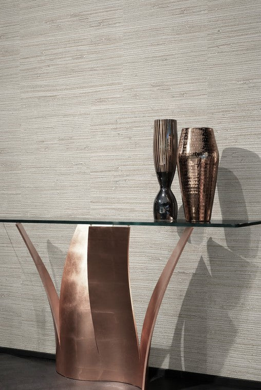A modern glass-top table with gold legs displays vases against a wall clad in Grasscloth Texture Grasscloth Naturals.