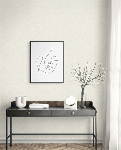 Minimalist entryway with a black console, abstract face art, and Natural Raffia Commercial Vinyl wallpaper for neutral style.