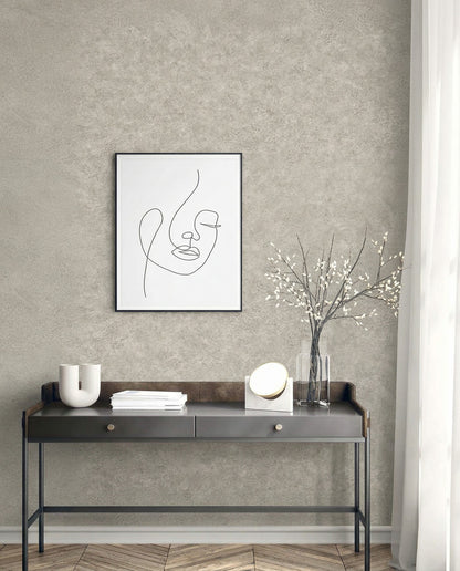 Minimalist console table with decor, abstract face art, and Florence Leather Commercial Vinyl wallpaper on gray wall.