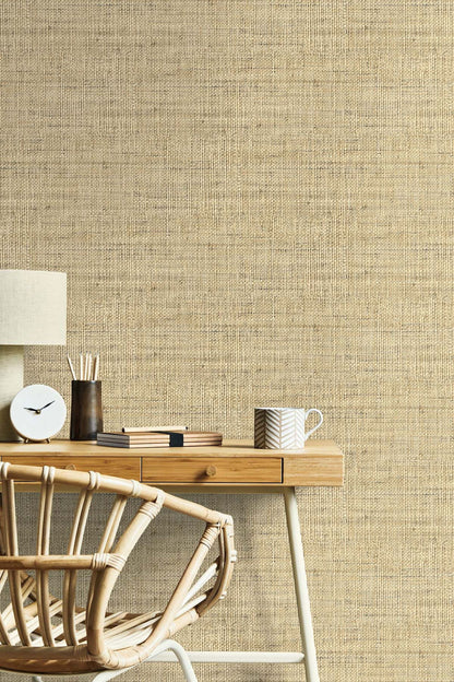 Wheat Beige Linen Fabric Commercial & Vinyl textured wallpaper with a wooden desk and chair in the foreground.