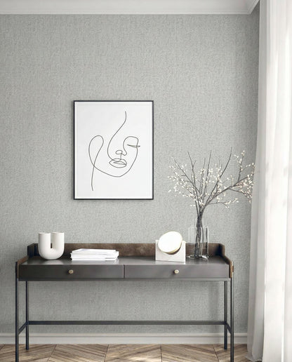 Minimalist desk with decor, vase, and art set against Faux Paperweave Commercial Vinyl wallpaper on a textured wall.