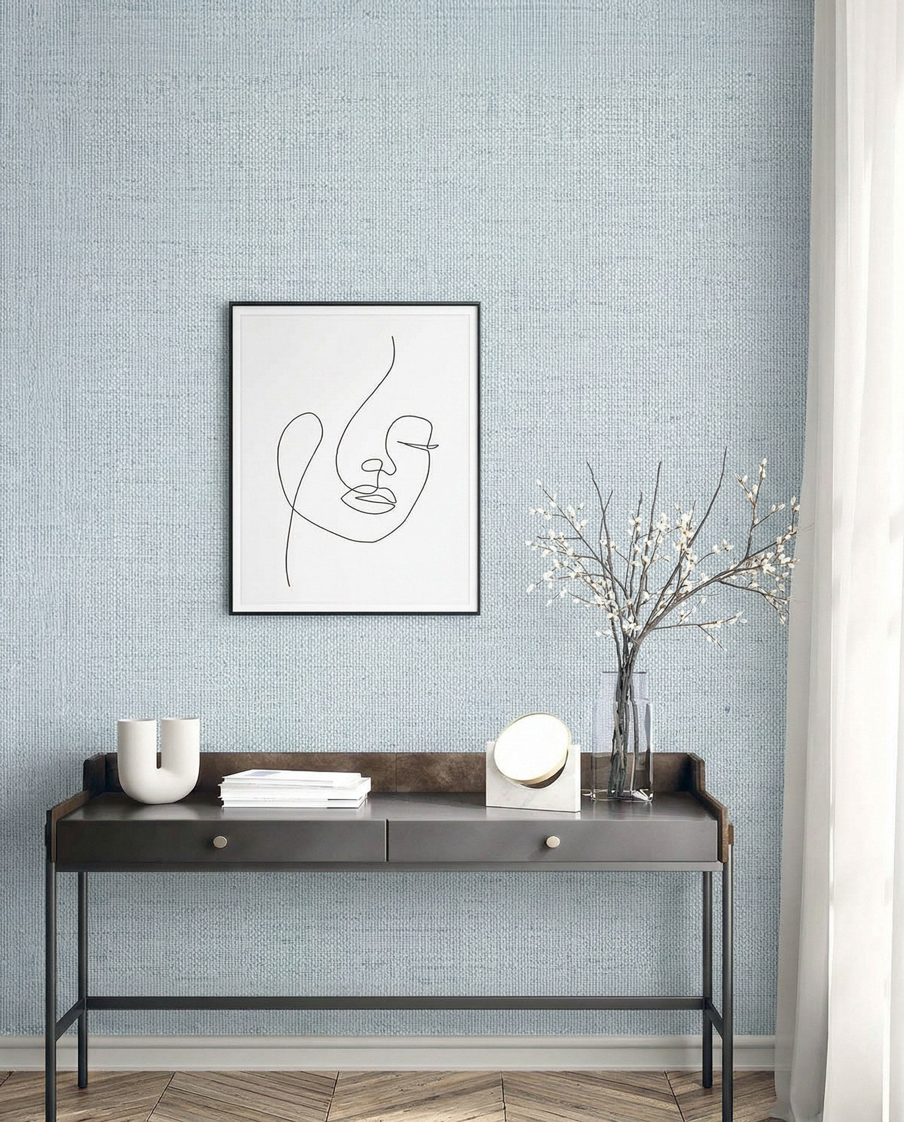 Minimalist desk with decor and art set against Faux Paperweave Commercial Vinyl wallpaper on a light textured wall.