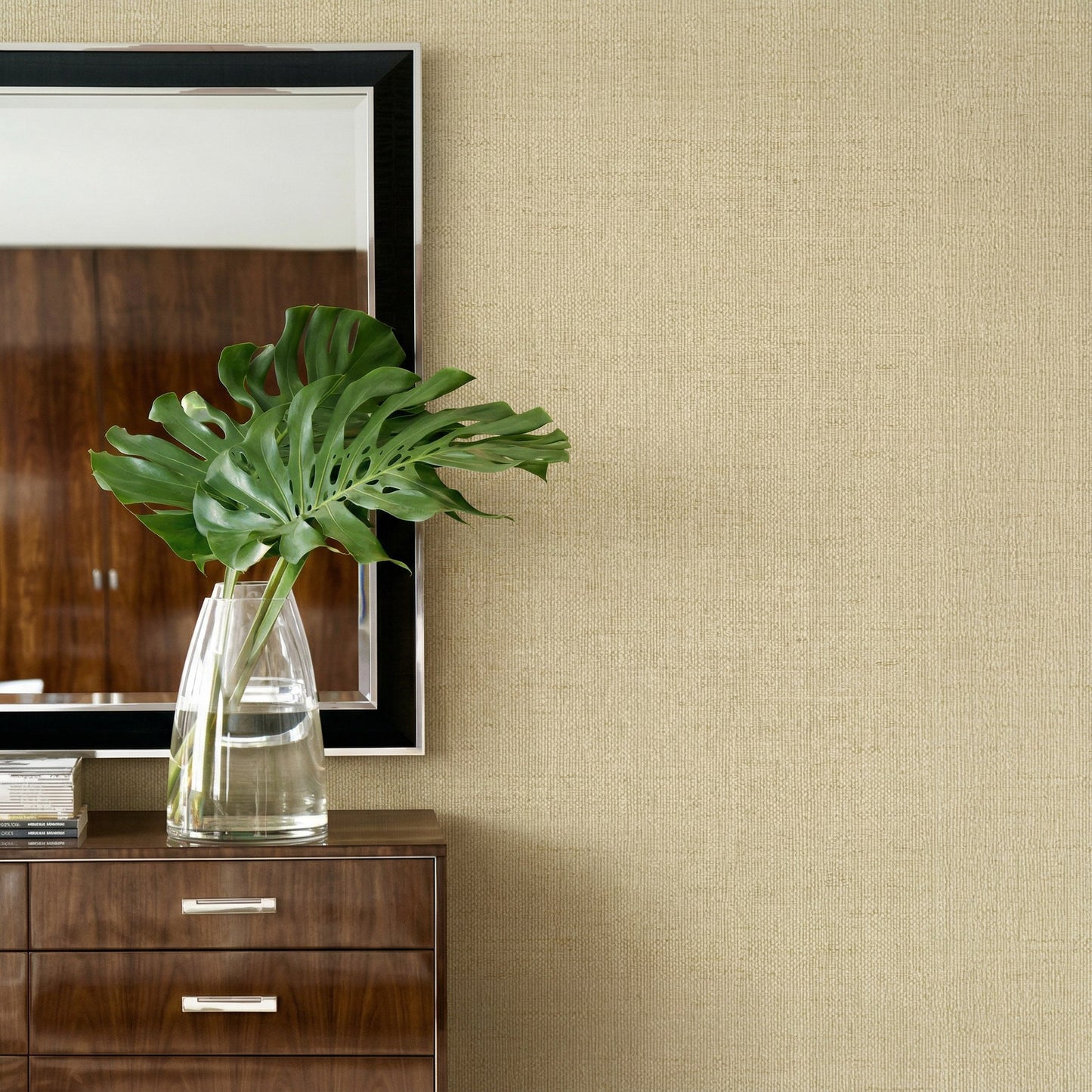 Glass vase with green leaves on a dresser, mirror on Faux Paperweave Commercial Vinyl wallpaper.