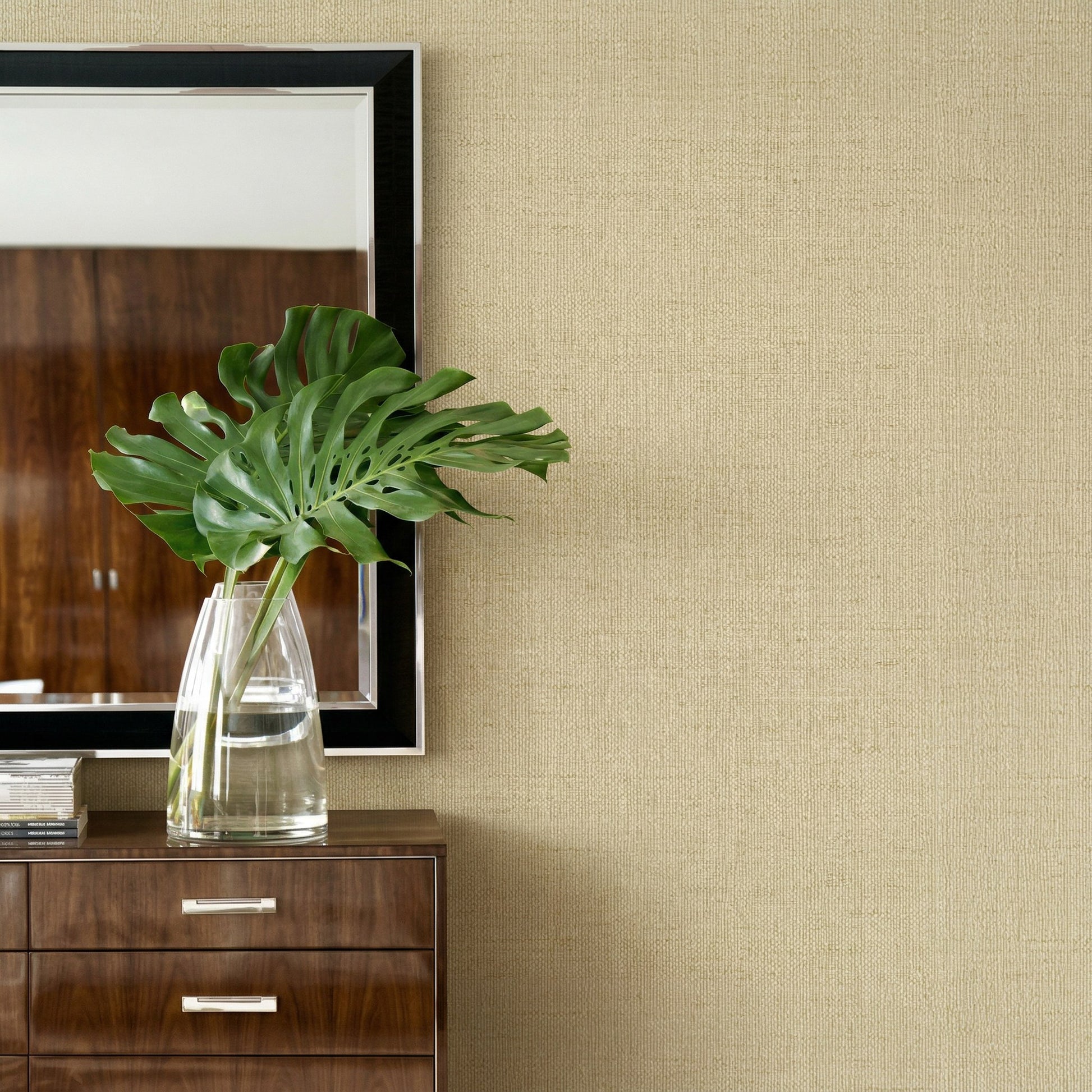 Glass vase with green leaves on a dresser, mirror on Faux Paperweave Commercial Vinyl wallpaper.