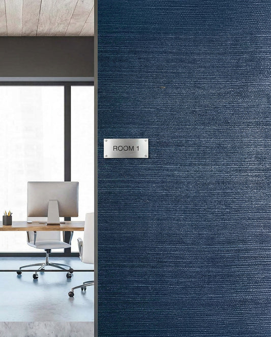 Modern office with desk and chair viewed through door, set against Sisal Texture Grasscloth Naturals on a blue wall.