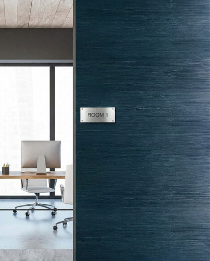 Modern office with desk and chair seen through doorway, featuring Straw Texture Grasscloth Naturals wall decor.
