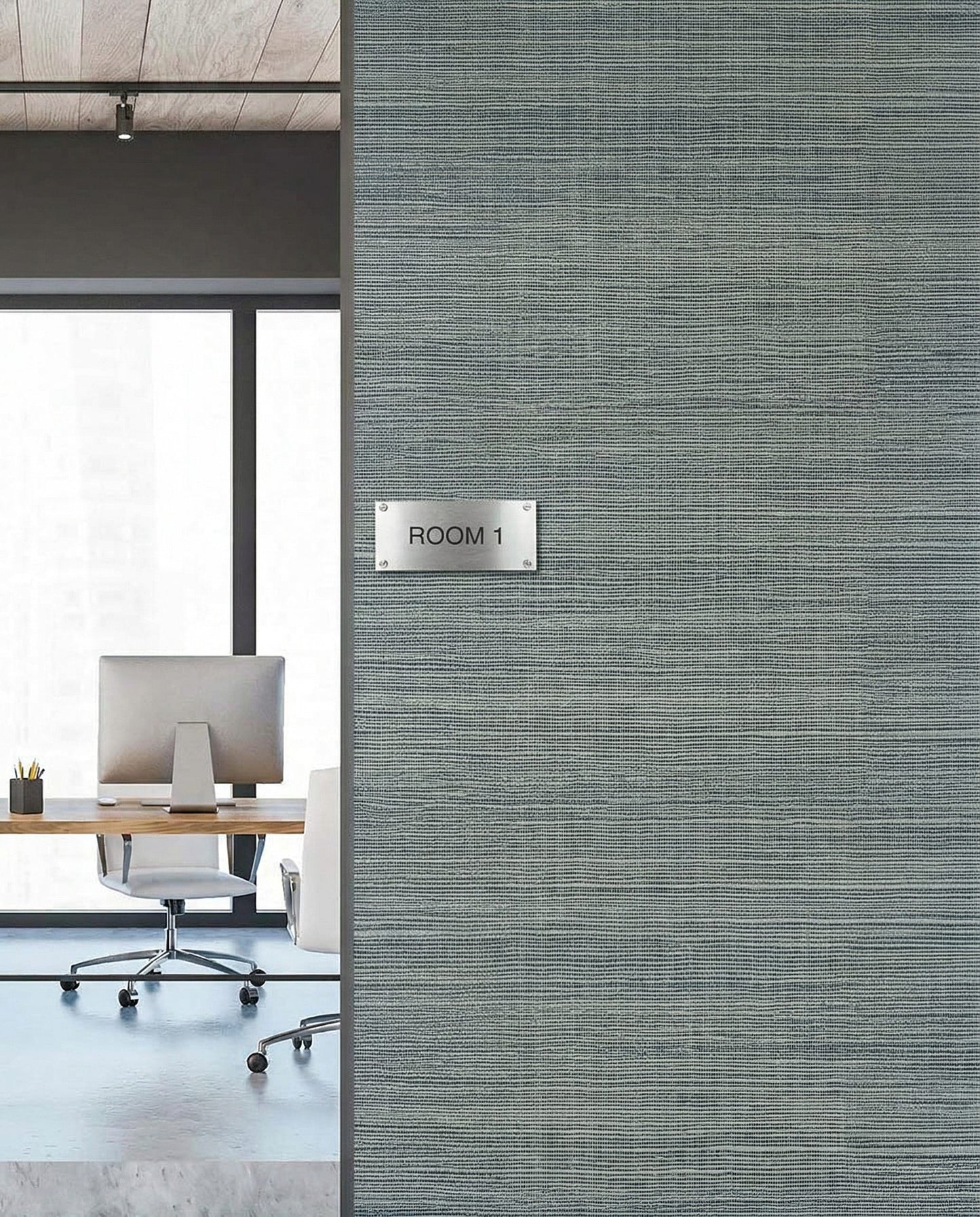 Office room with a ROOM 1 sign on Sisal Texture Grasscloth Naturals wallpaper, desk and chair seen through window.