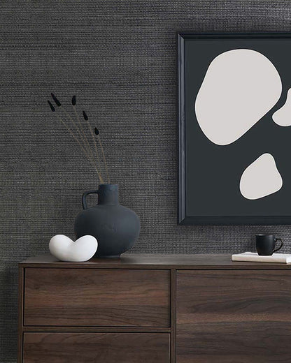 Minimalist decor with abstract art, black vase, and coffee cup on a dresser against Sisal Texture Grasscloth Naturals.