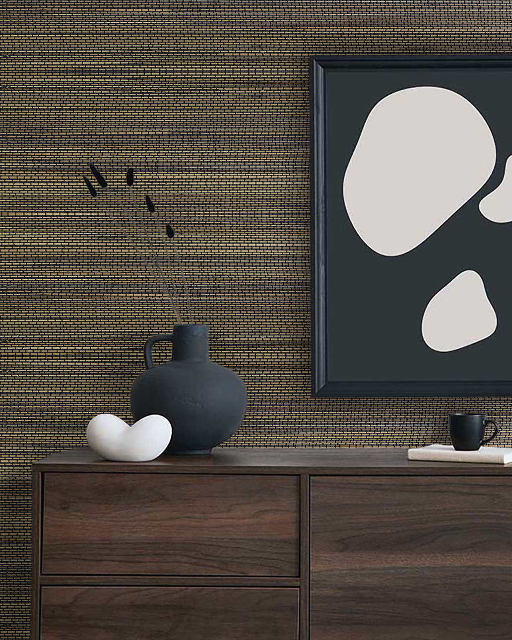 A dark wood dresser with decor sits beneath abstract art, featuring Straw Texture Grasscloth Naturals wallcovering.
