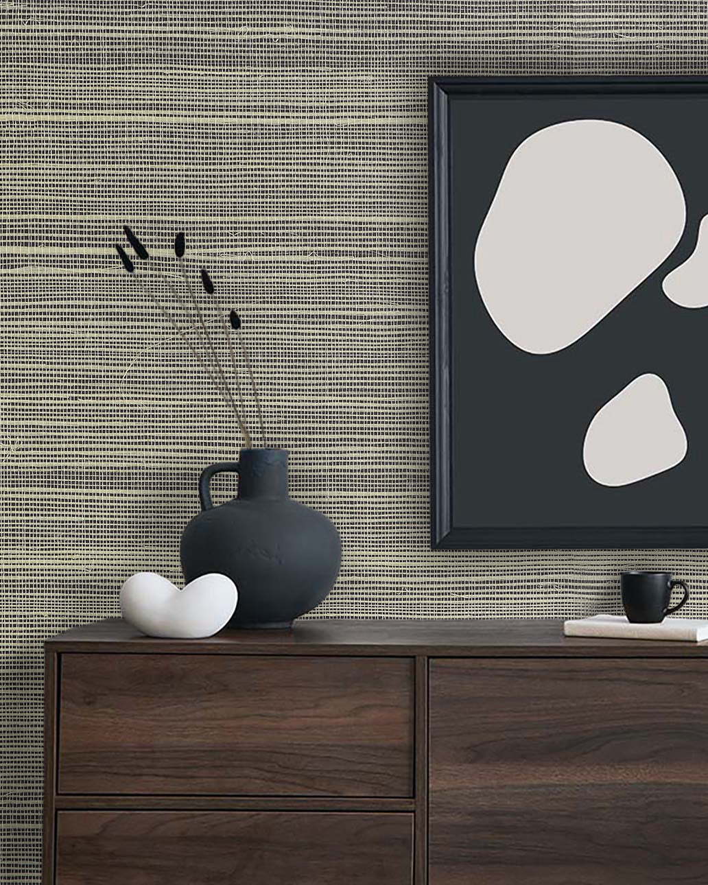A dark wood dresser with minimalist decor and abstract art stands against Sisal Texture Grasscloth Naturals wallpaper.