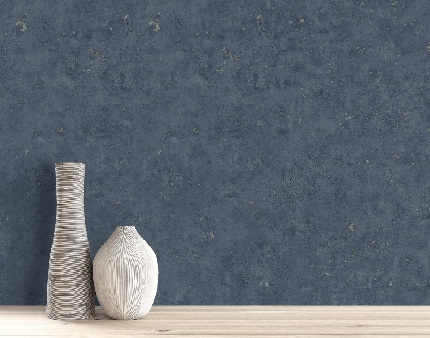 Two vases sit on wood against Cement Commercial Vinyl wallpaper, one tall striped, the other round and plain.